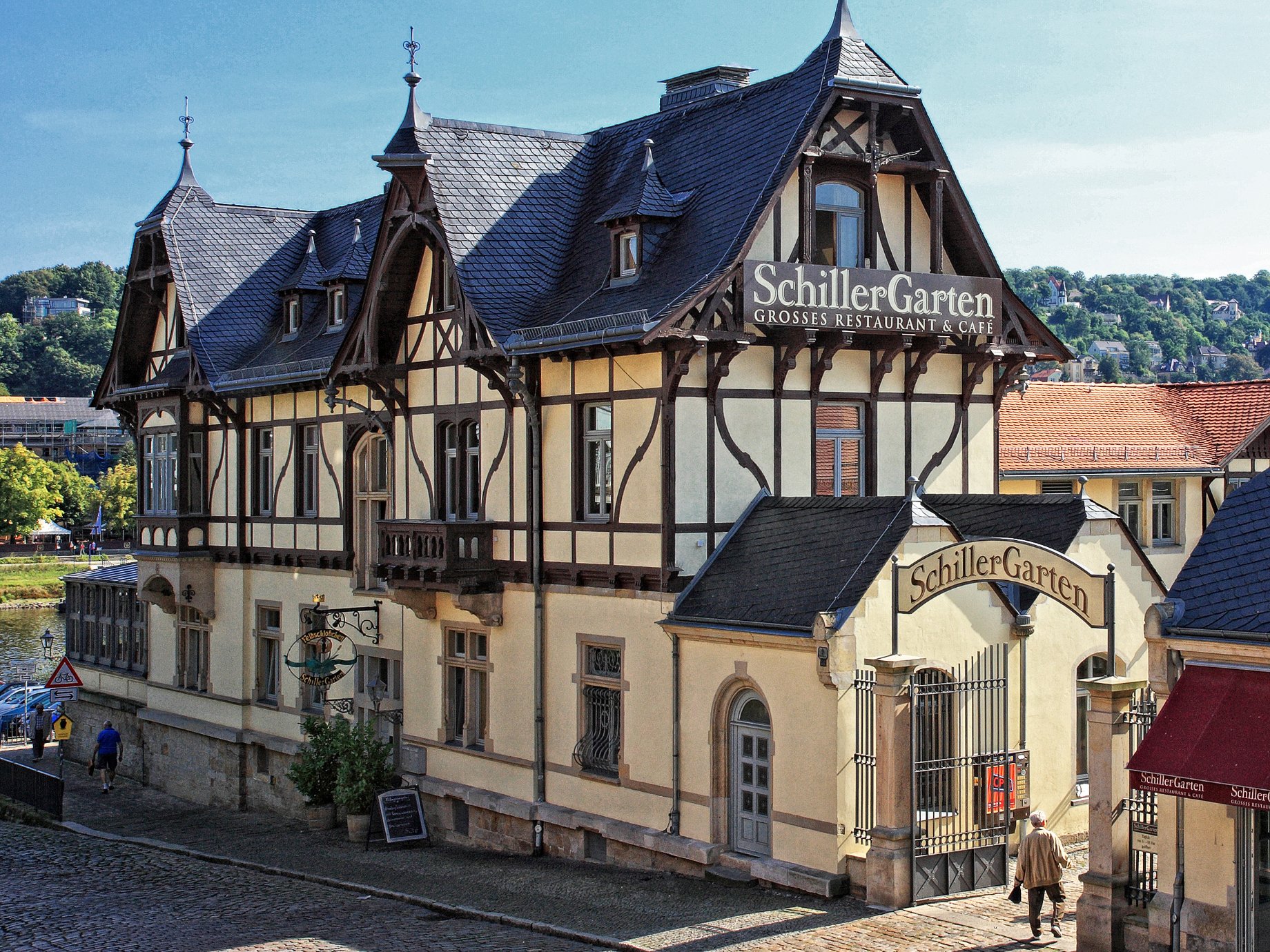 Ansicht des SchillerGartens. Fachwerkhaus mit davor liegender Pflastersteinstraße.