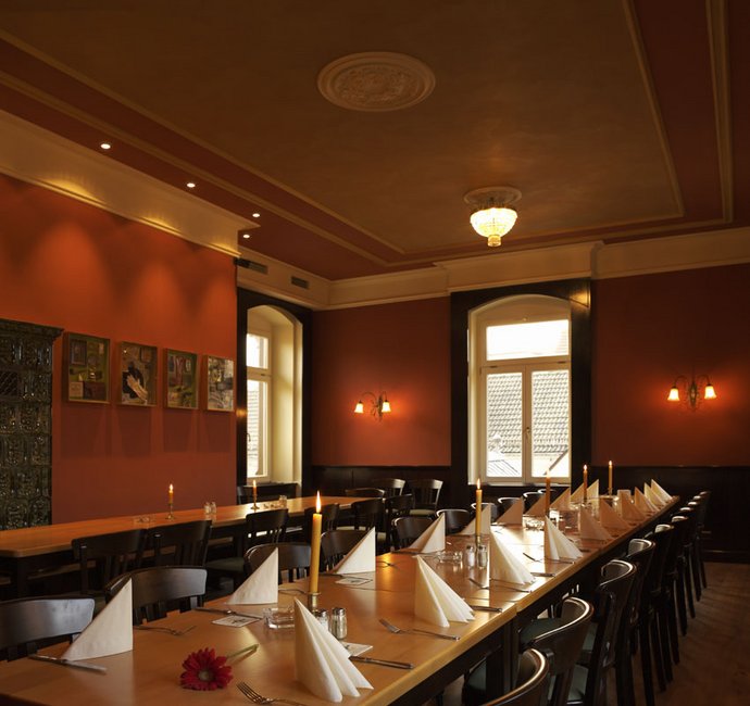 Eine lange Tafel, gedeckt mit Geschirr und Servietten
