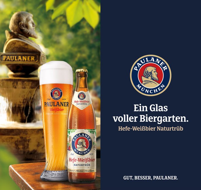Ein großes Glas und eine Flasche stehen auf einem Tisch in einem Biergarten. Dahinter steht eine Statue. Der Text dazu: "Ein Glas voller Biergarten, Hefe-Weißbier Naturtrüb"